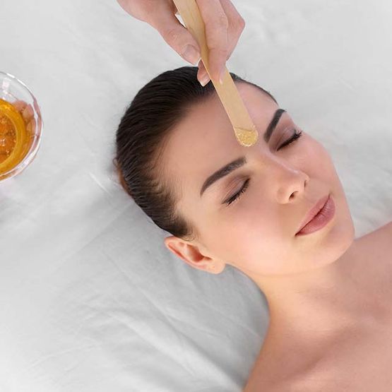 Mujer depilando cejas con cera